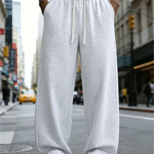 A pair of loose and fashionable sports trousers for men, with an outward-turned waistband and a color-blocked design. The wide-leg trousers are casual and simple, with a tie at the waist and large pockets, suitable for daily walks, work, travel, etc