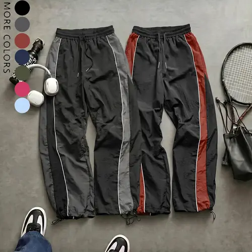 Men’s high-street style wide-leg pants with contrast color panels, side stripes, and a drawstring; American retro loose, drapey athletic pants; available in multiple colors; slim casual pants suitable for spring and summer wear.