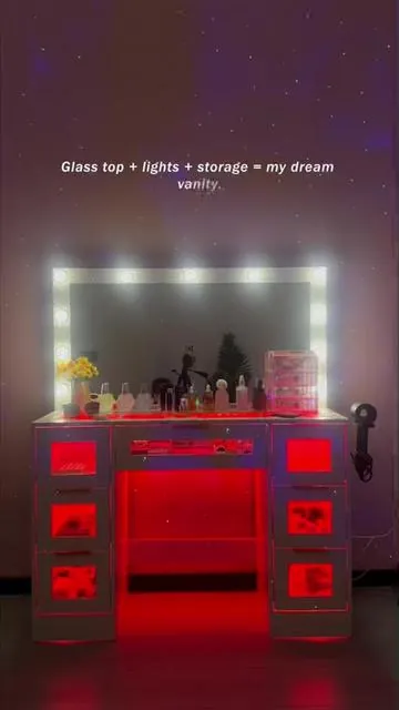 Glass top + lights + storage = my dream vanity! ✨ This vanity is all about style and functionality. The scratch-resistant tempered glass top is sleek and easy to clean. The Hollywood-style bulb mirror and bottom RGB ambient lighting create the perfect glow for stunning selfies. With multi-layer drawers, jewelry, makeup, and skincare are organized to perfection. It even has a dedicated spot for your hair dryer. A must-have for every beauty lover looking to level up their bedroom! tempered glass top vanity, LED bulb mirror vanity, large storage makeup desk, RGB lighting vanity, aesthetic white vanity, bedroom ambient furniture, modern vanity table, hair dryer holder vanity, multifunctional makeup station, cute vanity desk