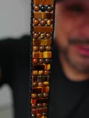 Pulsera de ojo de tigre tejida a mano, tipo brazalete ancho con piedras naturales rectangulares y redondas cosidas con cordón. En la tradición, el ojo de tigre se asocia con la confianza y el anclaje. Al ser piedra natural, el veteado dorado cambia de una pieza a otra. Es elástica, sin broche, y le queda a muñeca de 6.5 a 7.5 pulgadas. Se puede usar sola o apilada con otras. #Pulseras #OjoDeTigre #PiedrasNaturales #JoyeriaArtesanal #EstiloBoho 