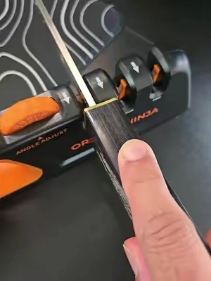 Keep your kitchen knives razor sharp with the Orange Ninja Adjustable Knife Sharpener. Adjustable sharpening angles, three-stage sharpening, and a non-slip base make it a must-have kitchen tool. #knifesharpener #kitchentools #kitchengadgets #homecooking #orangeninja