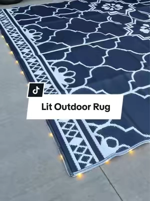 Can someone explain why every outdoor rug doesn’t do this? ✨ This reversible outdoor rug has built-in solar-powered LED lights that make your campsite, patio, deck, or backyard feel so cozy after dark. It even comes with a carry bag and ground stakes, making it perfect for camping, RV trips, tailgates, or outdoor entertaining. #OutdoorRug #CampingGear #CampingEssentials #RVLife #tiktokshopsummersale  