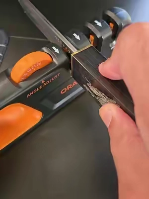 Sharpen kitchen knives, D2 steel blades, pocket knives, and more with the Orange Ninja Adjustable Knife Sharpener. Adjustable angles and a three-stage sharpening system make restoring dull blades quick and easy. #knifesharpener #d2steel #kitchentools #edcgear #orangeninja