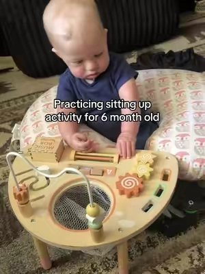 Working on sitting up while playing with this wooden activity center!